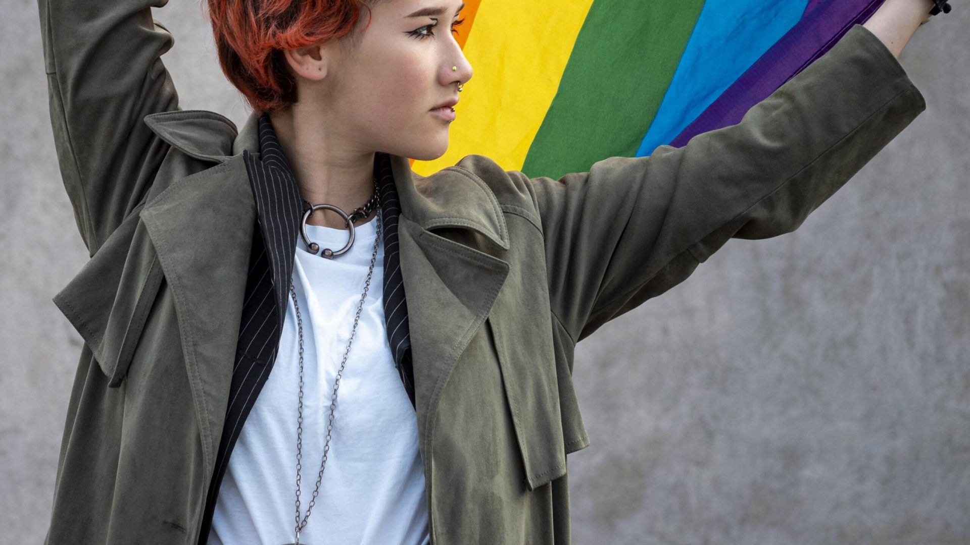 redhead-non-binary-person-holding-lgbt-flag FREEPIK